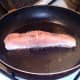 Starting to fry salmon fillet