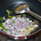 Heat oil in a deep-bottomed pan. Throw in cumin seeds. Let them sizzle. Add chopped onions, ginger, and slit green chilies.