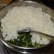 Step five: Add cooked rice. Gently mix it with the contents in the pan.