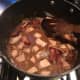 Add the bacon to the stew, boil, then cover and place in the oven.