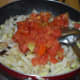 Step four: Throw in tomatoes. Stir-cook till tomatoes get mashed.