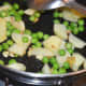 Step two: Throw in green peas and potatoes. Add some salt. Stir cook for 2 minutes.