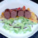 Halved venison sausages are laid on tortilla base