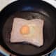 Egg is carefully poured in to a hole in the frying bread