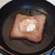 Eggy bread is turned to fry on its second side