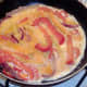 Beaten egg is poured over softened peppers and onion