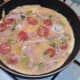 Egg is poured over sprouts and bacon combination