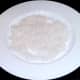 Cooked rice is spread out on a plate to cool