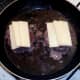 Cheese slices are laid on frying burgers