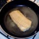 Cod fillet is turned in frying pan