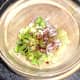 Prepared salad ingredients are added to a mixing bowl
