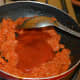 Step four: Add tomato sauce. Continue stir-cooking till you get a moderately thick paste