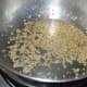 Step six: Heat remaining oil in a deep-bottomed pan. Throw in mustard seeds and sesame seeds. Let mustard crackle.