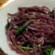 Pho noodles soaked in red wine, with sauteed spinach and purple onions