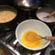 Step 2: In a separate large bowl combine together the 4 egg yolks and the 1/2 cup of sugar, with 1 teaspoon vanilla, and whisk until they are combined.