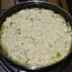 Step six: Spread the tempering evenly. Pour the handvo batter in the center. Spread it a little and flatten the top. Add some sesame seeds on the top.