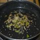 Step five: Add two tablespoons of oil into a non-stick pan. Throw in mustard seeds, curry leaves, and sesame seeds. Saute until mustard pops up.