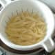 Penne pasta is drained and allowed to steam