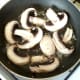 Sliced mushrooms are added to garlic oil to fry