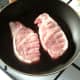 Pork fillets are seasoned and added to frying pan