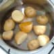 Salt and turmeric are added to prepared potatoes