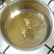 Garlic and herbs are added to oil in saucepan