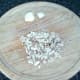 Mushroom stems are moderately finely chopped and garlic cloves are peeled