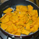Step two: Add thinly sliced pumpkin. Continue to saute for 1 minute.