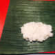 Place two tablespoons of steamed rice over the banana leaf.