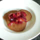 Cooled stewed plums are spooned on to pancakes