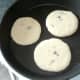 Pancake batter is ladled in to frying pan