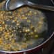 Step two: Heat oil in a deep-bottomed pan. Add mustard seeds. Let them crackle. Throw in split chickpea and white lentils. Saute over low fire until the lentils become golden brown.