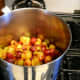 Place the pitted plums in a saucepan, kettle, or stock pot. You can make any amount of jam you like, but a deeper pot requires more stirring and is apt to stick. Two shallow pots are better than one huge one. Add water as necessary. Use low heat.