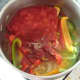Tomatoes and seasonings are added to peppers and onion