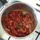 Dried herbs are added to beans in saucepan
