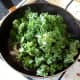 Kale is added to frying pan with chilli, garlic and onion