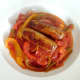 Chicken sausages are laid on peppers in spicy tomato sauce