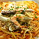 Pancit luglog: Thick rice noodles softened in hot water, stirred in a thickened shrimp sauce, and topped with steamed shrimp, hard-boiled egg, smoked fish, squid, and chopped pechay baguio.