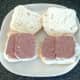 Slices of corned beef are laid on cut open bread rolls