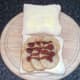 Brown sauce is drizzled over potatoes before sandwich is closed over with second slice of bread