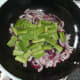 Chopped green beans added to stir fried onion