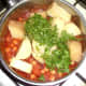 Potatoes and coriander/cilantro are added to chickpea curry