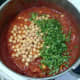 Chickpeas and coriander are added to chicken curry