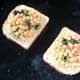 Sandwich filling is spread on bread on grill pan