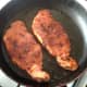 Spicy pork fillets are added to hot frying pan