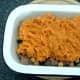 Cooled sweet potato mash is spooned on to pie filling