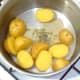 Butter and dried fenugreek leaf are added to drained potatoes