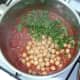 Chickpeas and coriander are added to spicy tomato sauce