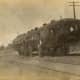Railroad men in their uniform standing by an unusual passenger railroad car, Heavener