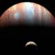 Jupiter and Io photographed by the New Horizons space probe to Pluto, passing by in 2007. (Jupiter is captured in infrared, which maps heat, so the Great Red Spot looks white). Note eruption plume on Io's pole (right).